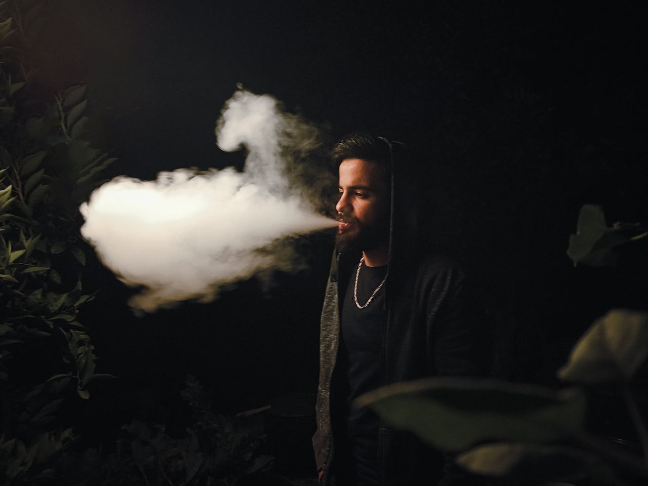 about-img Portrait of a man exhaling thick vapor at night outdoors in Fethiye, Türkiye.